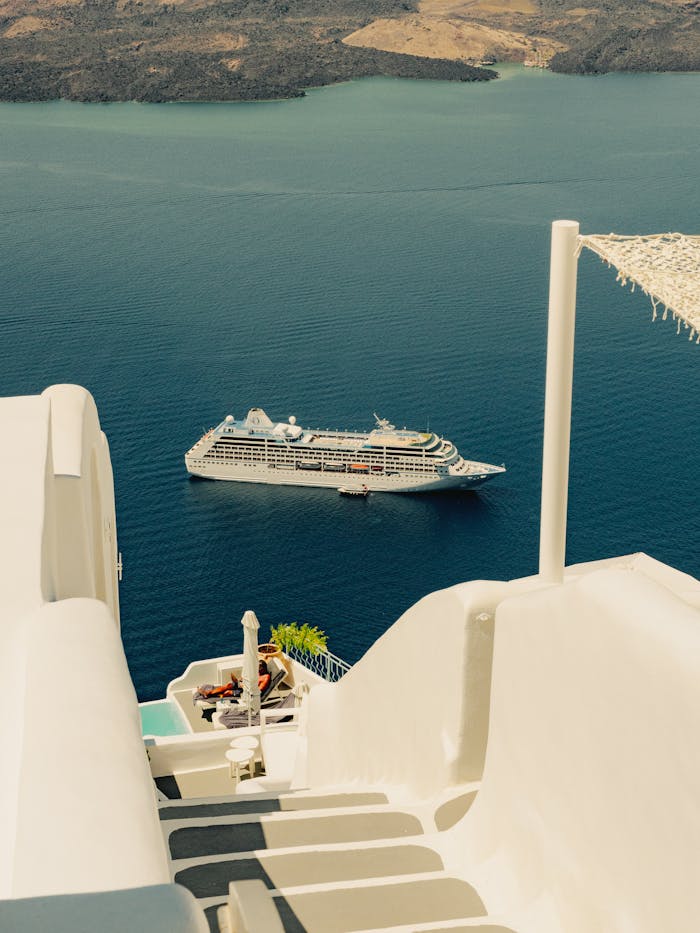Serene view of a cruise ship from the iconic white buildings of Santorini.